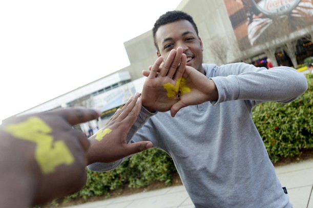 Michigan fan Tyler Corneous, 18, of Atlanta, flashes a block M that he had painted on his plams outside of the Georgia Dome before the start of the national championship game in Atlanta on Monday, April 8, 2013. Melanie Maxwell I AnnArbor.com